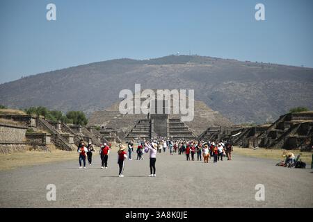 Touristen machen Fotos von sich auf der Allee der Toten (Calzada de los Muertos) in Teotihuacan. Im Hintergrund ist die Mondpyramide zu sehen. Teotihuacan ist eine archäologische Stätte im Tal von Mexiko, die von 100 v. Chr. bis zu ihrer Aufgabe zwischen dem 5. Und 6. Jahrhundert entwickelt wurde. Die Stätte wurde 1987 zum UNESCO-Weltkulturerbe erklärt. Es ist eine der meistbesuchten archäologischen Stätten in Mexiko. Stockfoto