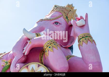 Gigantische rosa Ganesha-Statue. In Ganeshas Händen hält er einen gebrochenen Stoßzähn in einer Hand und einen Lotusschollen. Wat Saman Rattanaram, Chachoengsao, Thailand Stockfoto