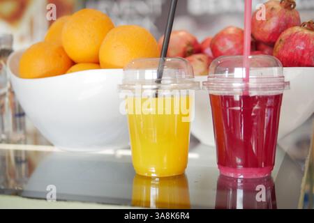 Frisch zubereitete Fruchtsäfte werden an einem lebhaften Marktstand ausgestellt Stockfoto
