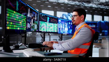 Latino Engineer überwacht das SCADA-System der Ölraffinerie auf dem Desktop. Stockfoto