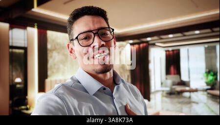 Reiseinfluencer Im Hotelzimmer. Happy Man Streamt Auf Der Kamera Stockfoto