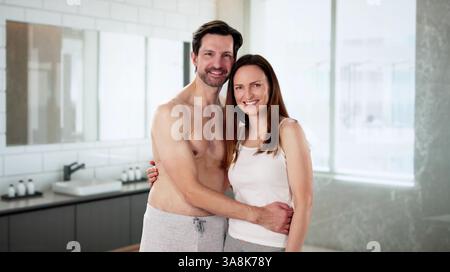 Glückliches Paar im Badezimmer, das sich gemeinsam um ihre Haut kümmert. Mann und Frau genießen Hautpflege-Routine im Badezimmer zu Hause. Stockfoto
