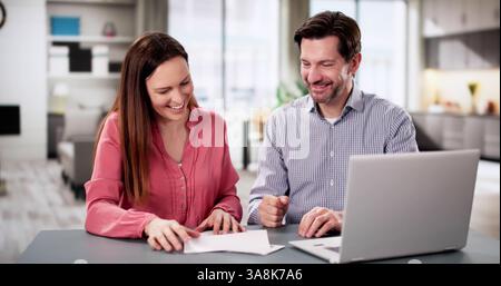 Porträt eines glücklichen jungen Paares zu Hause, das Papier liest. Stockfoto