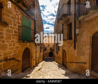 Enge malerische Gassen mit Holztüren und mittelalterlichen Steinhäusern in Calaceite, Teruel. Stockfoto