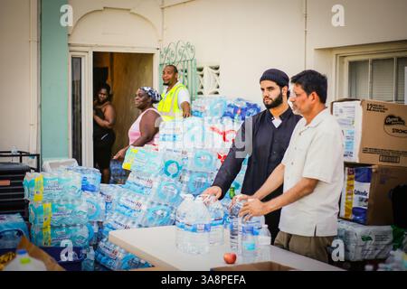 17. September 2017 – FL, USA – Immam Sultan und Sohail Kothari helfen, Wasser an die Bewohner von Liberty City zu verteilen, die am Sonntag, 17. September 2017 in der Masjid Al-Ansar Moschee in Miami, Florida, vom Hurrikan Irma betroffen sind (Kreditbild: © Zak Bennett/TNS via ZUMA Wire) Stockfoto