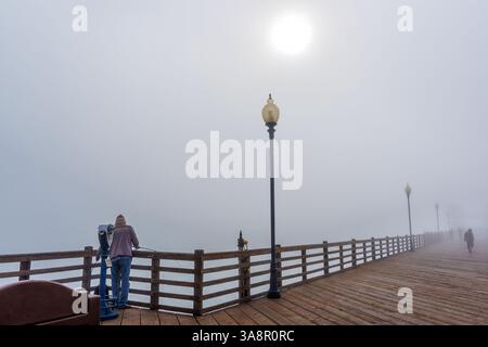 Oceanside, Kalifornien - 3. Januar 2025: Fisherman steht am Oceanside Municipal Pier in Kalifornien, umgeben von Nebel, und hält einen ruhigen Moment fest Stockfoto