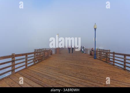 Oceanside, Kalifornien - 3. Januar 2025: Malerischer Blick auf den Oceanside Municipal Pier in Kalifornien, bei dem Menschen spazieren gehen und die nebelige Atmosphäre genießen Stockfoto