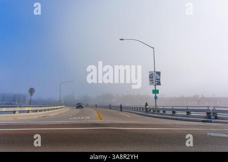 Oceanside, Kalifornien - 3. Januar 2025: Die nebelummantelte Straßenszene in der Nähe von Oceanside Harbor Village fängt eine ruhige Atmosphäre mit minimaler Sichtbarkeit ein Stockfoto