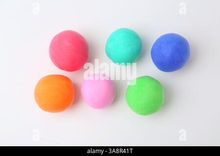 Verschiedene bunte Spielteigkugeln auf weißem Hintergrund, flache Lagen Stockfoto