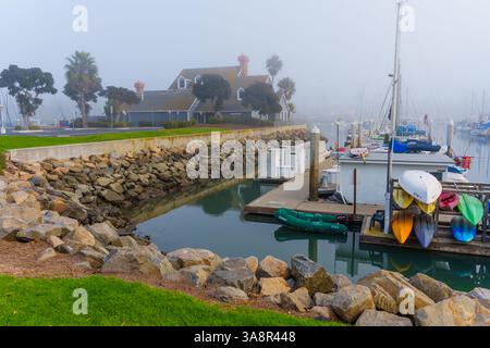 Oceanside, Kalifornien - 3. Januar 2025: Ruhiger Yachthafen in Oceanside, Kalifornien, mit Nebel, Booten und felsigen Küsten aufgenommen in sanftem Morgenlicht Stockfoto