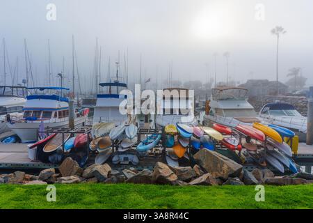 Oceanside, Kalifornien - 3. Januar 2025: Ruhiger Blick auf einen Yachthafen in Oceanside, Kalifornien, mit farbenfrohen Kajaks, die auf einem Dock inmitten eines Nebels stehen Stockfoto