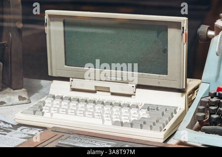 Triest, Italien - 18. August 2024: Ein alter Toshiba-Laptop, mit staubiger Tastatur und leerem Bildschirm, in einem Vintage-Ambiente. Stockfoto