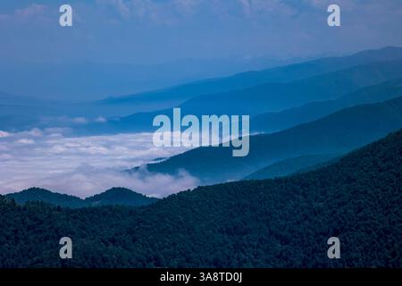 Atemberaubende Bergschichten, bedeckt von Nebel und Wolken Stockfoto
