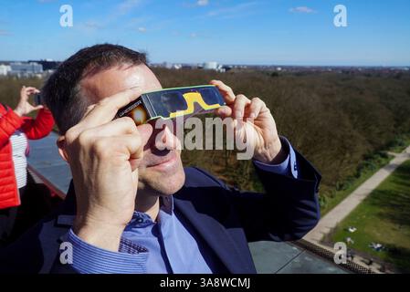 Leiter des Planetariums Björn Voss mit Schutzbrille. Die Partielle Sonnenfinsternis in Hamburg am 29.03.2025 gut zu sehen Hunderte von Zuschauern bewundern das Naturschauspiel von der Aussichtsplatform auf dem Planetarium mit Schutzbrillen und per Fernrohr die partielle Sonnenfinsternich dauert von ca 2 Stunden der Mond schob sich zum Teil vor die Sonne und verdeckte diese zu ca. 20 Prozent. Links auf der Sonne sieht man auch zum Teil die sogenannten Sonnenflecken Dort sind die Temperaturen auf der Sonne etwas niedriger. Die Bilder der Sonnenfinsternis sind mit einer speziellen Astrofolie als Stockfoto