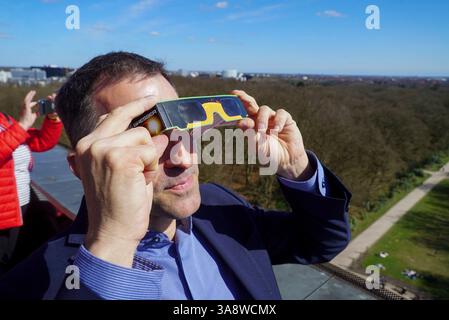Leiter des Planetariums Björn Voss mit Schutzbrille. Die Partielle Sonnenfinsternis in Hamburg am 29.03.2025 gut zu sehen Hunderte von Zuschauern bewundern das Naturschauspiel von der Aussichtsplatform auf dem Planetarium mit Schutzbrillen und per Fernrohr die partielle Sonnenfinsternich dauert von ca 2 Stunden der Mond schob sich zum Teil vor die Sonne und verdeckte diese zu ca. 20 Prozent. Links auf der Sonne sieht man auch zum Teil die sogenannten Sonnenflecken Dort sind die Temperaturen auf der Sonne etwas niedriger. Die Bilder der Sonnenfinsternis sind mit einer speziellen Astrofolie als Stockfoto