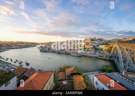 Porto, Portugal - Ein atemberaubender Blick auf den Sonnenuntergang auf die Brücke Dom Luis I und die lebendige Architektur am Fluss. Stockfoto