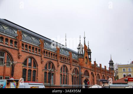 Danzig, Polen - 11.11.2024: Die historische Markthalle (Hala Targowa) in Gdańsk, ein Wahrzeichen für Shopping und lokale Produkte im Winter. Stockfoto