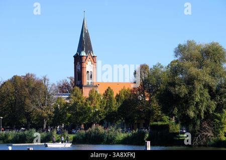Malerisches Landschaftspanorama von Werder, Havel, Brandenburg, mit einem Dampfer, der auf dem Fluss vor dem Wahrzeichen der katholischen Kirche Maria Meeresstern abfährt Stockfoto