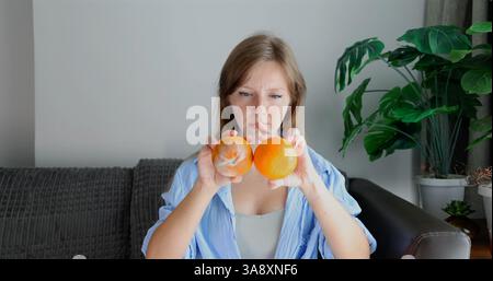 Frau, die frischen Pfirsich auf Couch, gesunde Ernährung Wertschätzung, Stockfoto