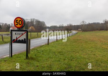 Kivik, Schweden, 07. März 2020: Asphaltstraße, Ortsendschild für Kivik und Geschwindigkeitsbegrenzung 50. Wald im Hinterland. Bewölkter, nasser Tag. Stockfoto