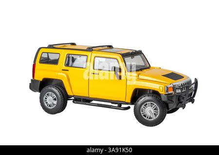 Ein gelbes Spielzeugmodell Hammer USA SUV Offroad ist auf weißem Hintergrund geparkt. Das Auto ist glänzend und gut gepflegt und vermittelt ein Gefühl von Luxus und soph Stockfoto