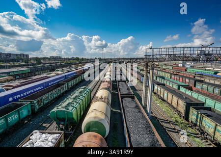 Ein Bahnhofshof mit vielen verschiedenen farbigen Zugwagen. Die Zugwagen sind meist schwarz und rot. Der Bahnhofbahnhof ist voll mit Zügen und die Züge sind parken Stockfoto