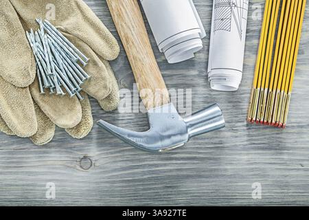 Leder-Sicherheitshandschuhe Krallenhammer Nägel Blaupausen Holzmessgerät Konstruktionskonzept Stockfoto