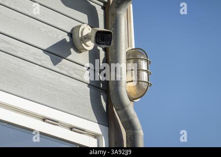 Überwachungskamera und Außenbeleuchtung gewährleisten die Sicherheit eines modernen Gebäudes Stockfoto