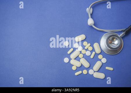 Draufsicht eines Stethoskops mit Pillen auf blauem Hintergrund und großem Kopierraum Stockfoto