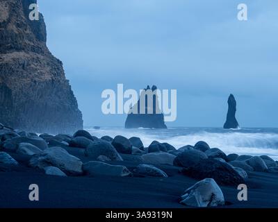 Reynisfjara Beach mit dramatischen Basaltsäulen und Reynisdrangar-Meeresstapeln. Die zerklüfteten Vulkangesteine und mächtigen Wellen schaffen ein faszinierendes und rotes Bild Stockfoto