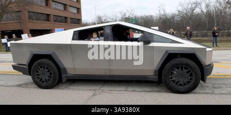 Northbrook, Illinois, USA. März 2025. Ein Kind schaut aus dem Truck-Fenster auf Demonstranten, während ein Tesla Cybertruck vorbeifährt. Am Samstag, den 29. März 2025, protestieren schätzungsweise 200 Menschen vor dem Tesla-Händlerbetrieb in Northbrook, Illinois, einem Vorort von Chicago. Der Tag wurde als weltweiter Aktionstag gegen Elon Musk und Tesla bezeichnet. (Kreditbild: © Mark Hertzberg/ZUMA Press Wire) NUR REDAKTIONELLE VERWENDUNG! Nicht für kommerzielle ZWECKE! Quelle: ZUMA Press, Inc./Alamy Live News Stockfoto