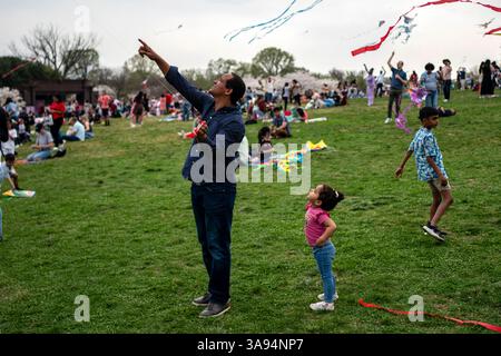Washington, Usa. März 2025. Ein Vater zeigt seiner Tochter den fliegenden Drachen während des Blossom Kite Festivals, einer Veranstaltung im Rahmen des National Cherry Blossom Festivals, in der National Mall in Washington, DC am Samstag, den 29. März 2025. Gestern haben die Kirschblüten ihren Höhepunkt erreicht, was die National Park Services definiert, wenn 70 % der Yoshino Kirschblüten geöffnet haben. Foto: Bonnie Cash/UPI Credit: UPI/Alamy Live News Stockfoto