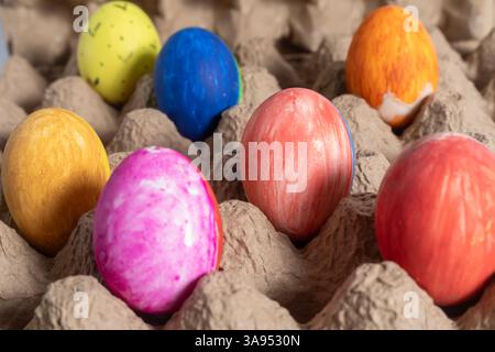 Farbenfrohe Ostereier mit künstlerischen Mustern, die festliche und traditionelle Osterfeste darstellen, werden in einem Karton ausgestellt. Stockfoto
