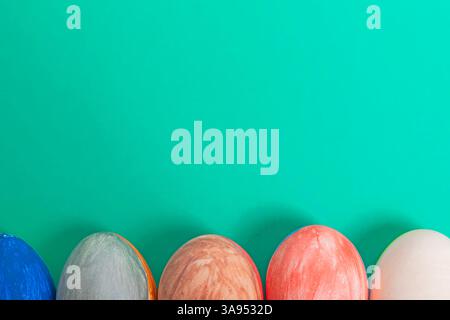 Eine Gruppe kunstvoll dekorierter Ostereier mit einem bunten Hintergrund, der den festlichen Geist der Ostern repräsentiert. Stockfoto