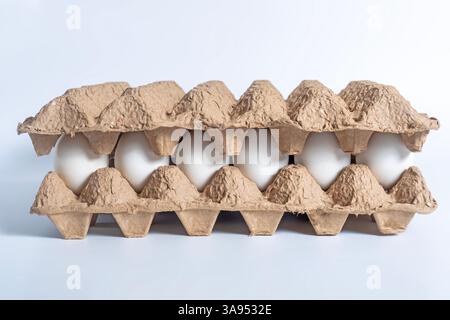 Eine Nahaufnahme von Eierkartons aus Pappe mit weißen Eiern, geeignet für Lebensmittelindustrie, Verpackungen oder Kochthemen; Stockfoto