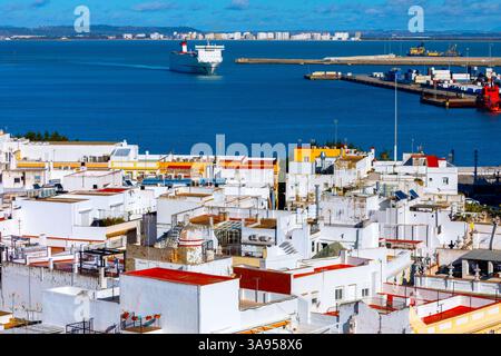 Bay of Cadiz bietet einen bezaubernden Kontrast zwischen weiß getünchten Gebäuden und glitzernden Gewässern der Bucht dahinter. Ein großes Schiff gleitet in Richtung Stockfoto