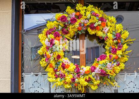 Heller Kranz aus gelben und rosa Blumen draußen Stockfoto