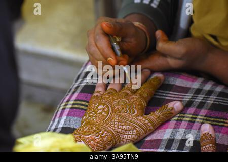 Srinagar, Indien. März 2025. Ein Mehndi-Künstler entwirft ein wunderschönes Mehndi-Muster auf der Hand eines Kaschmirmädchens auf dem Goni-Khan-Markt, um beim Eid-ul-Fitr-fest (Breaking Fast Feast) einzukaufen. Am 29. März 2025 in Srinagar, Indien. (Foto von Danish Showkat/ Eyepix Group) Credit: SIPA USA/Alamy Live News Stockfoto