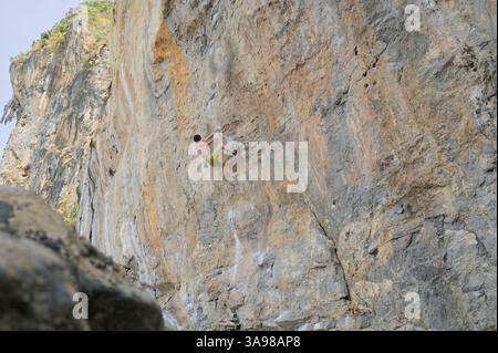 Ein freier Alleinsteiger steigt in Tonsai, einem der beliebtesten Kletterziele der Welt, über eine gewaltige Kalksteinmauer hinauf Stockfoto