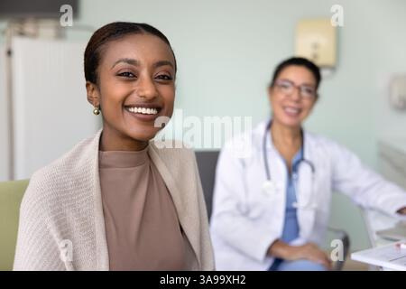 Glückliche, schöne junge afroamerikanische Patientin, die in die Kamera schaut Stockfoto