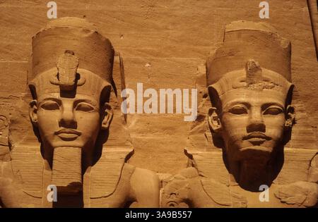 Zwei kolossale Gesichter des größten Herrschers des alten Ägypten: Kopf und Schultern von zwei der vier 20 m hohen, sitzenden Bildnisse des Neuen Königreichs der 19. Dynastie Pharao, Ramesses II., säumen die Fassade des Großen Tempels aus dem 13. Jahrhundert v. Chr., den er in Abu Simbel im alten Nubien, heute Assuan Governate, Ägypten, erbaute. Stockfoto