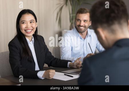 Multiethnische positive und freundliche Geschäftsleute nehmen an Geschäftsgesprächen Teil Stockfoto