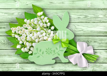 Grüner Osterhase mit Blumen auf hölzernem Hintergrund Stockfoto