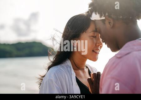 Sorgloses Paar genießt einen tropischen Strandurlaub und lacht zusammen unvergessliche Erinnerungen Stockfoto