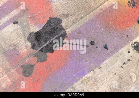 Malt violette und gelbe und weiße und rote und schwarze Flecken auf einem Holzbrett als Hintergrund, mehrfarbiger abstrakter Hintergrund Stockfoto