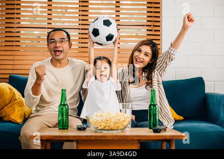 Eine glückliche Familie genießt den Nervenkitzel eines Fußballspiels zu Hause Stockfoto