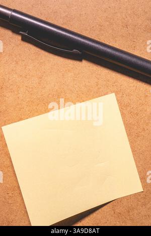Eine klebrige Notiz auf braunem Hintergrund. Stockfoto
