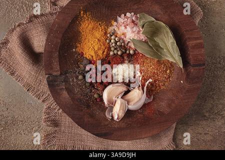 Gewürzmischung, Knoblauch und Lorbeerblatt, auf Holzteller, Nahaufnahme, Lebensmittelkonzept, keine Leute Stockfoto