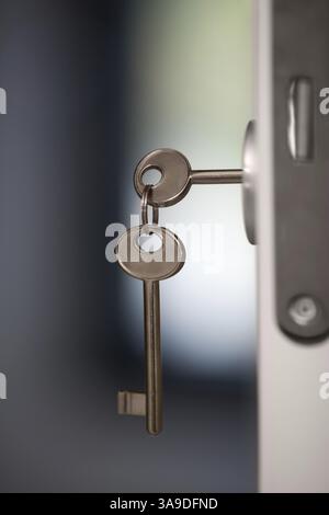 Nahaufnahme der Schlüssel im Schloss der offenen Tür. Ein Schlüssel ist im Schloss ein weiteres hängen auf dem ring Stockfoto