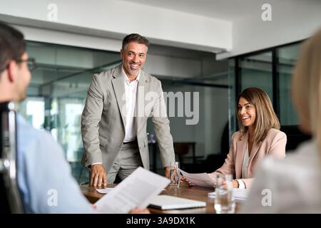 Zufriedene Mitarbeiter des Geschäftsteams, die bei Gruppenbesprechungen im Unternehmen diskutieren. Stockfoto